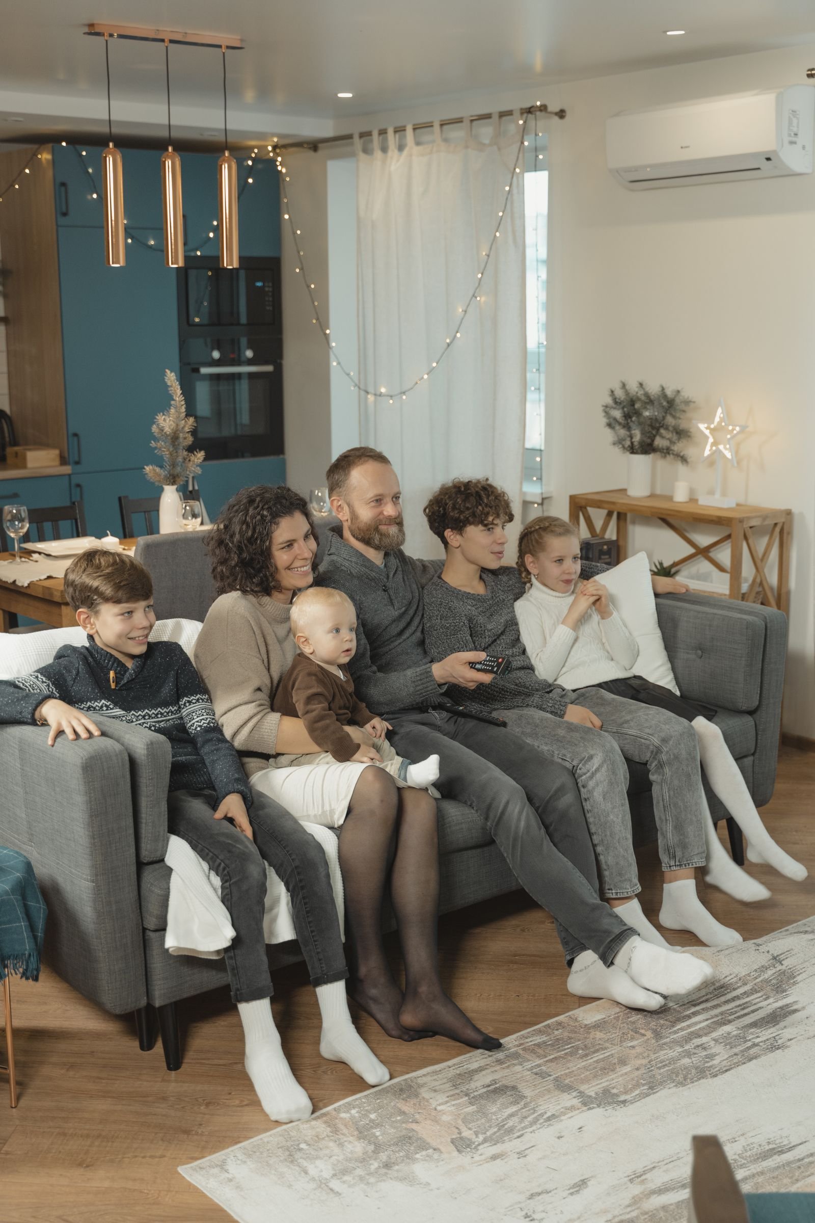 Familie schaut gemeinsam Fernsehen auf dem Sofa